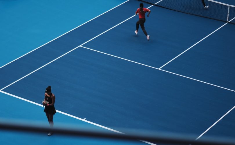 two person playing tennis during daytime